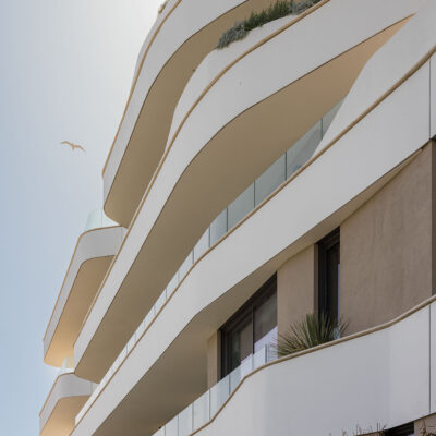 Geschwungene Balkone und Bepflanzung von the ONE Ibiza im Gegenlicht.