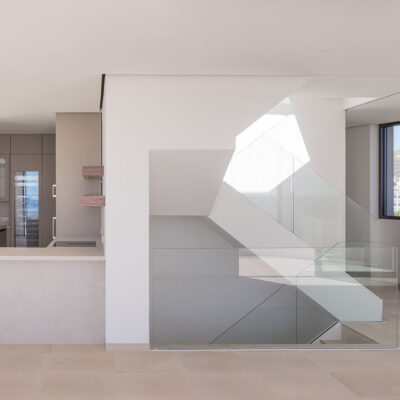 Kitchen and interior staircase of the ONE Ibiza lit by a skylight.