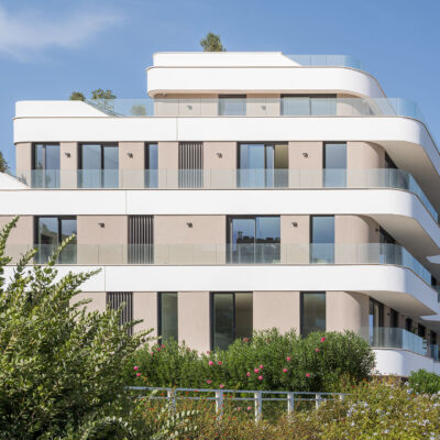Fachada lateral de the ONE Ibiza con balcones y vegetación.
